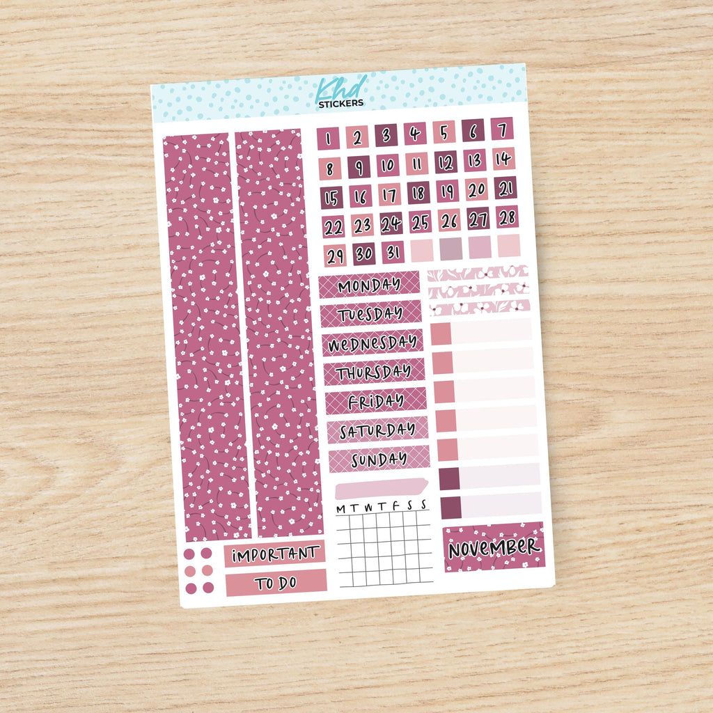 a pink and white planner sticker on a wooden surface